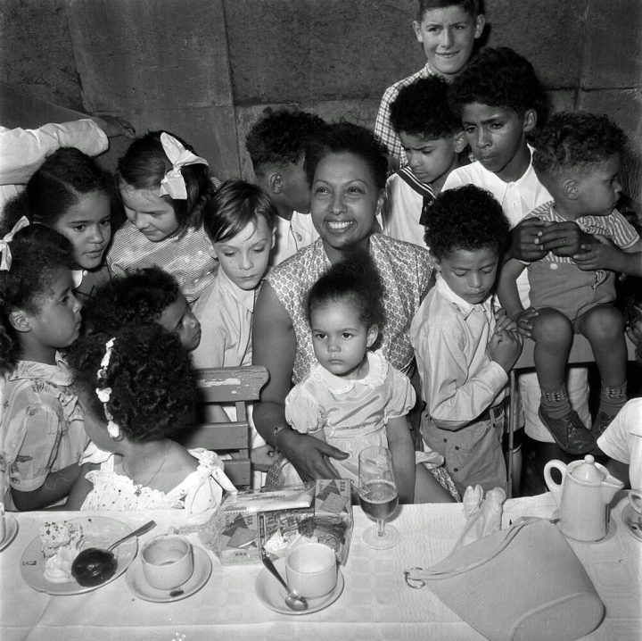 Beim Besuch des Berliner Zoos bewirtet Josephine Baker Berliner Kinder mit Kuchen und Schokolade.